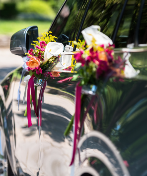 A wedding car decorated with flowers and ribbons