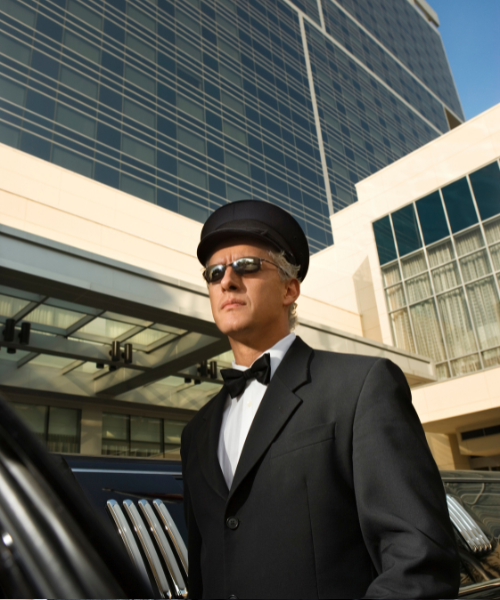 A man in a tuxedo is standing in front of a car