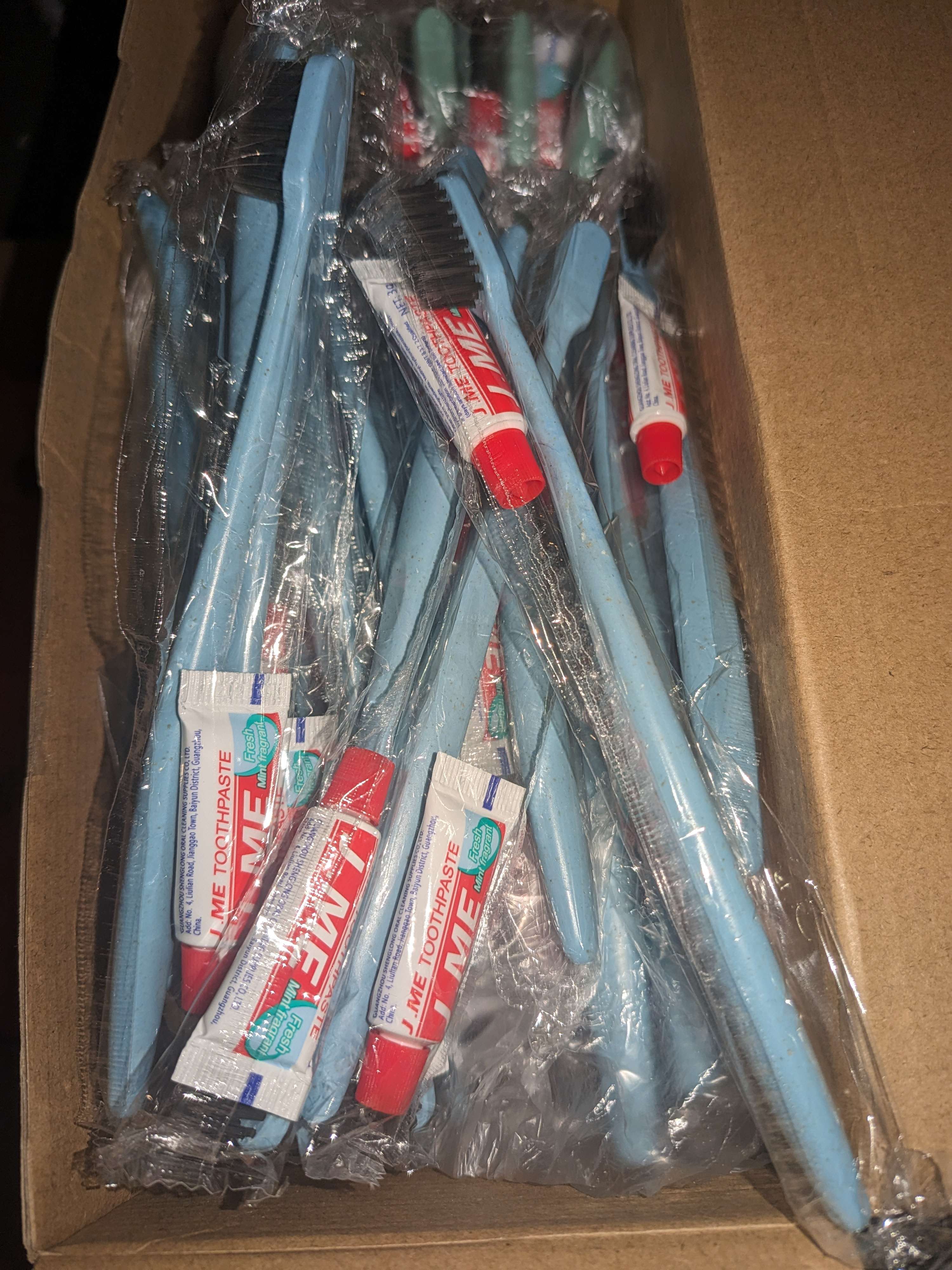 A box filled with blue toothbrushes and toothpaste