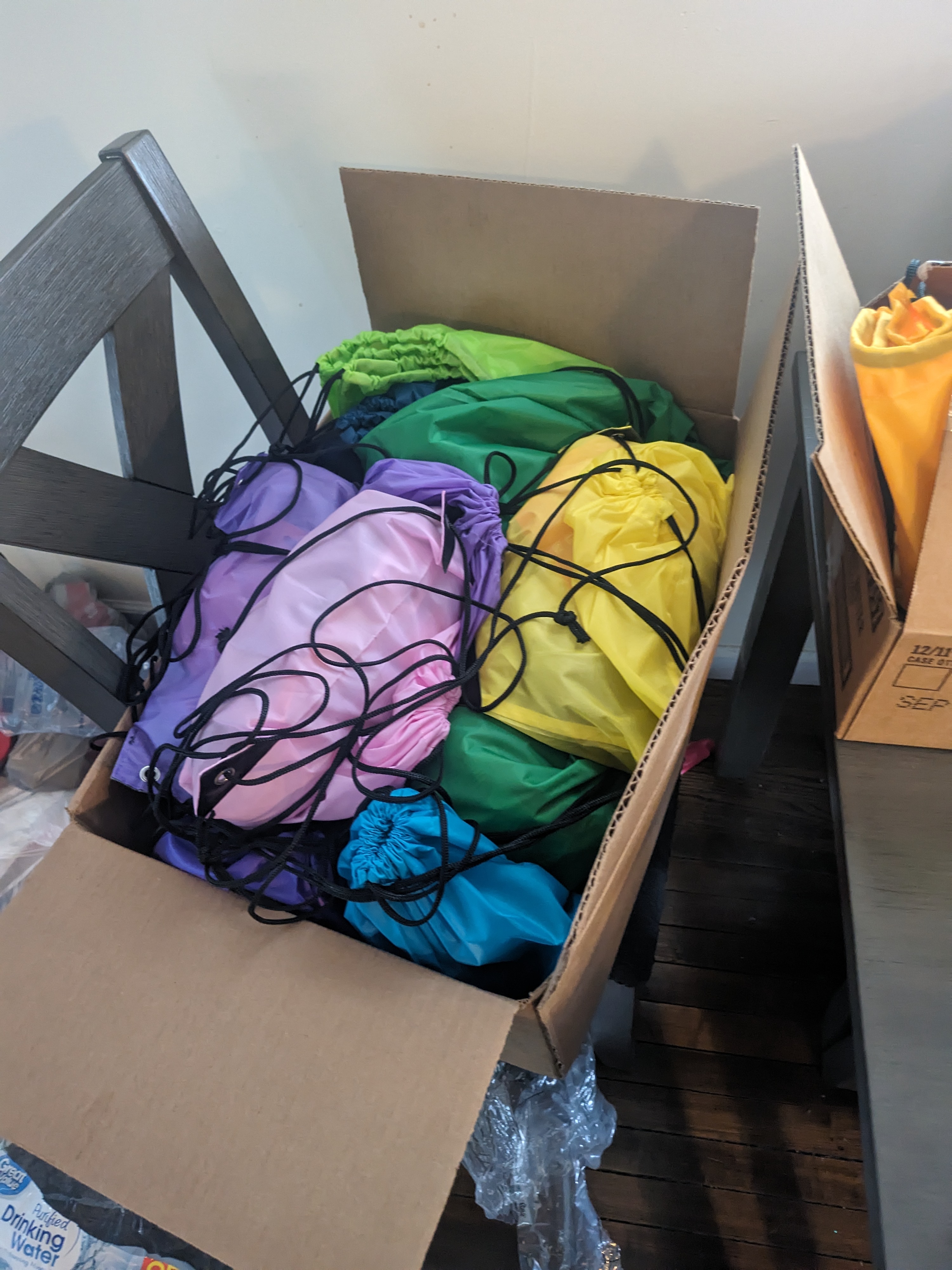 A cardboard box filled with different colored shirts